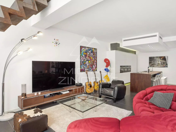 Intérieur d'un loft d'architecte à Antibes avec salon moderne et cuisine ouverte.