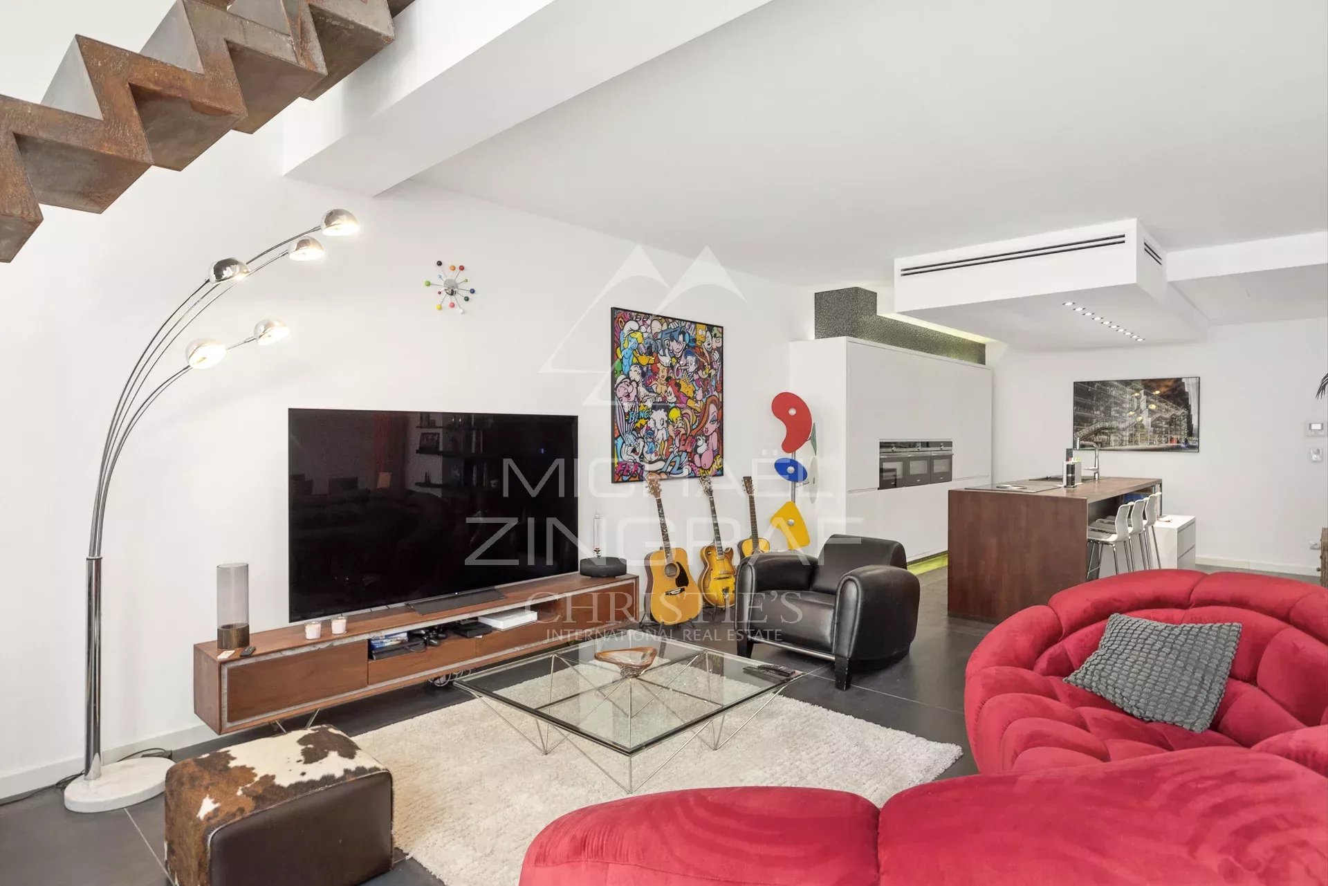 Intérieur d'un loft d'architecte à Antibes avec salon moderne et cuisine ouverte.