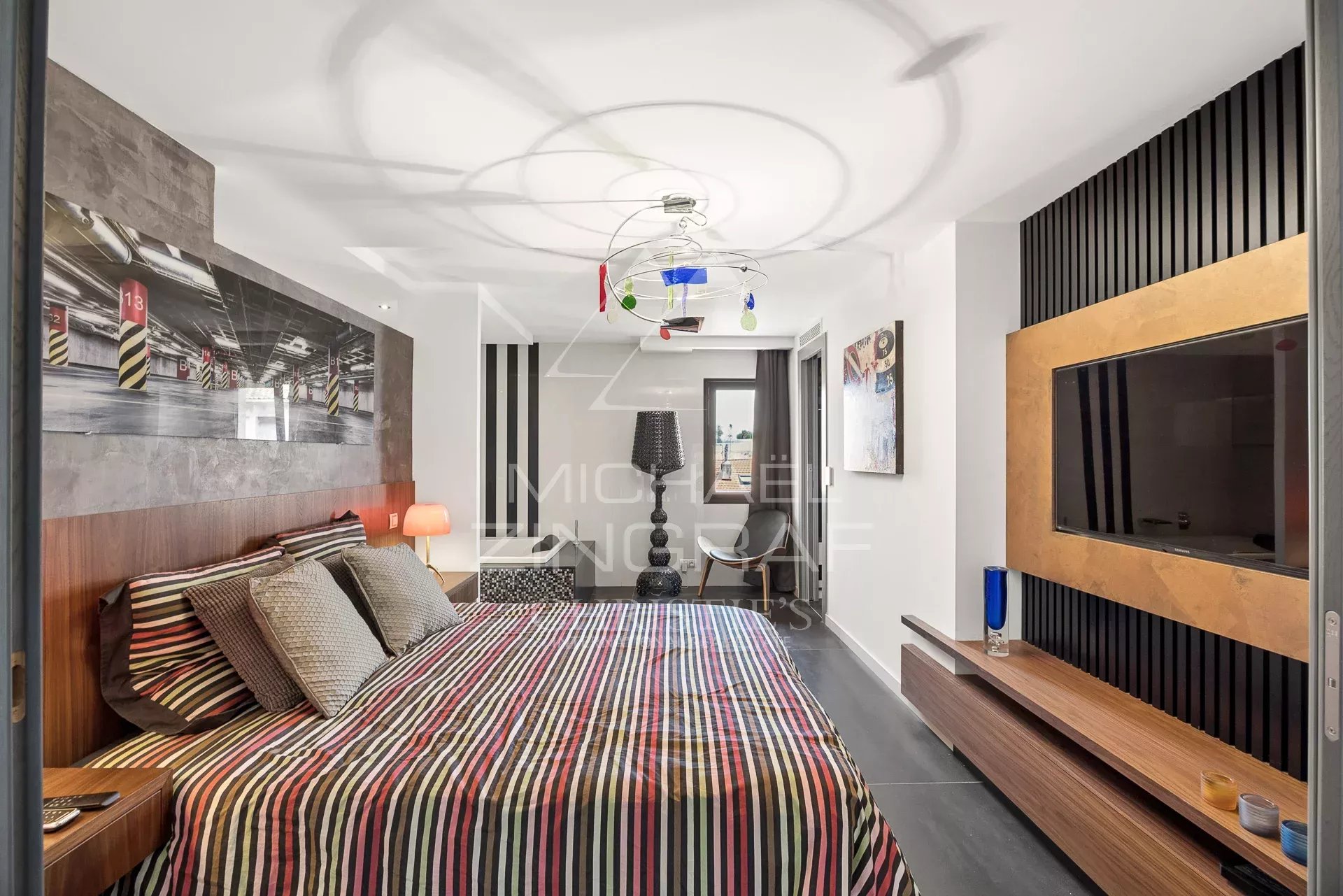 Chambre d'un loft d'architecte à Antibes avec décoration moderne et télévision murale.