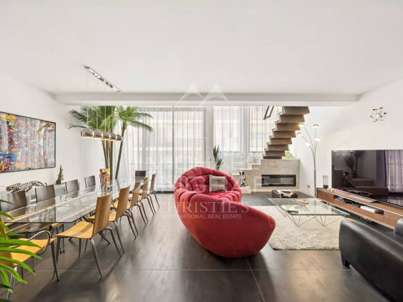 Intérieur d'un loft d'architecte à Antibes avec salon, salle à manger et escalier moderne.