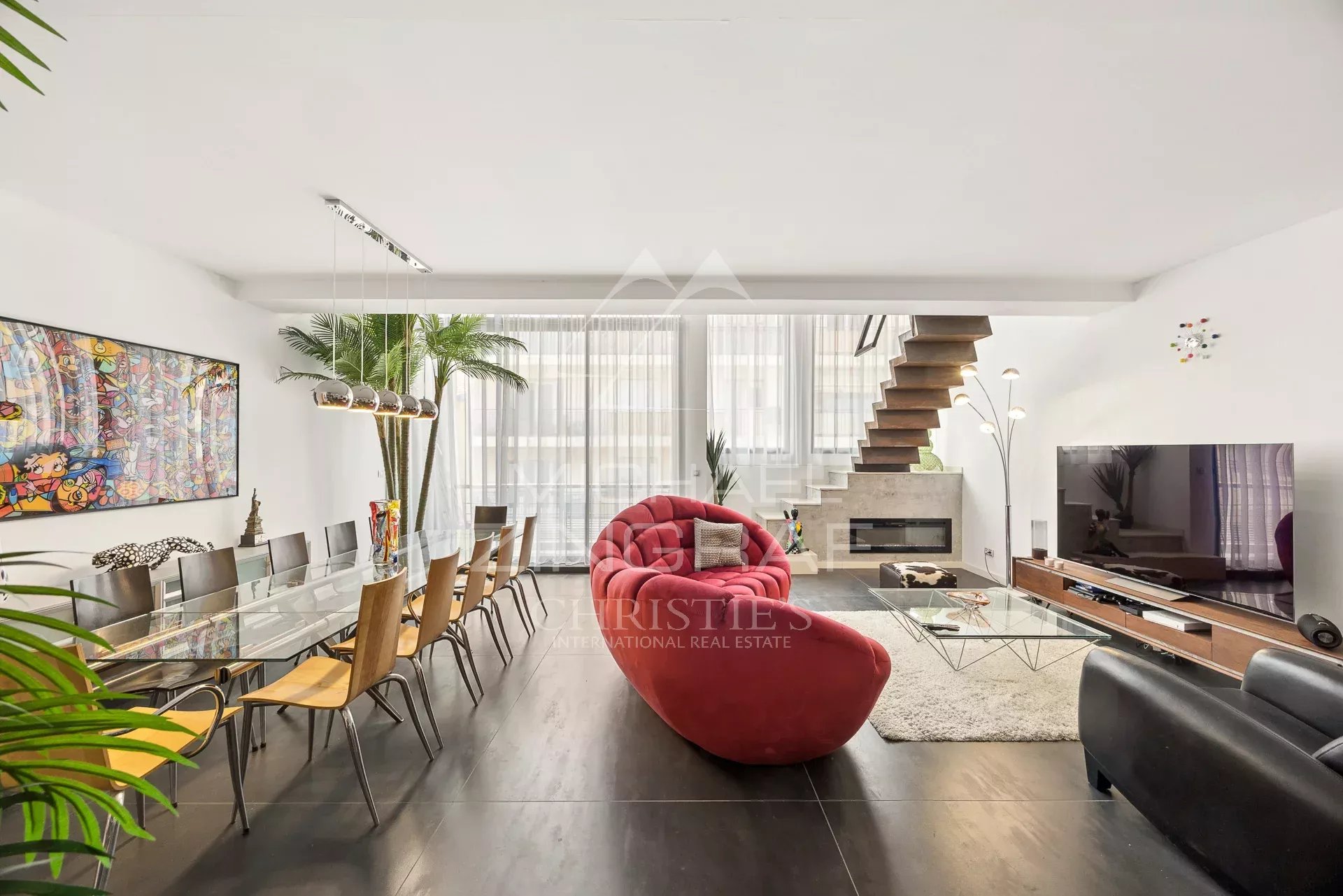Intérieur d'un loft d'architecte à Antibes avec salon, salle à manger et escalier moderne.