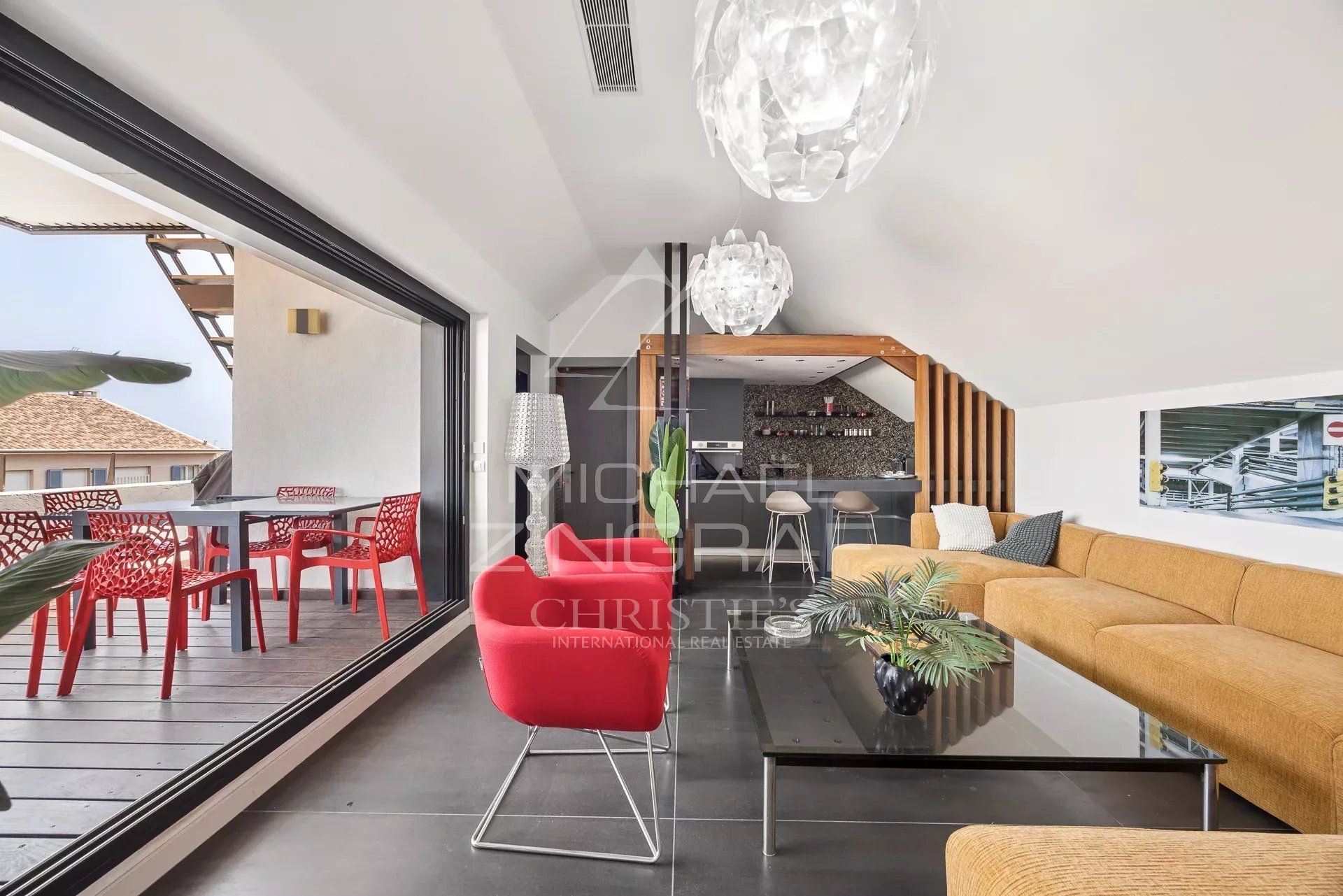 Intérieur d'un loft d'architecte à Antibes avec un salon moderne et une vue sur une terrasse.