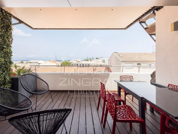 Terrasse d'un loft d'architecte à Antibes avec mobilier moderne et vue dégagée.