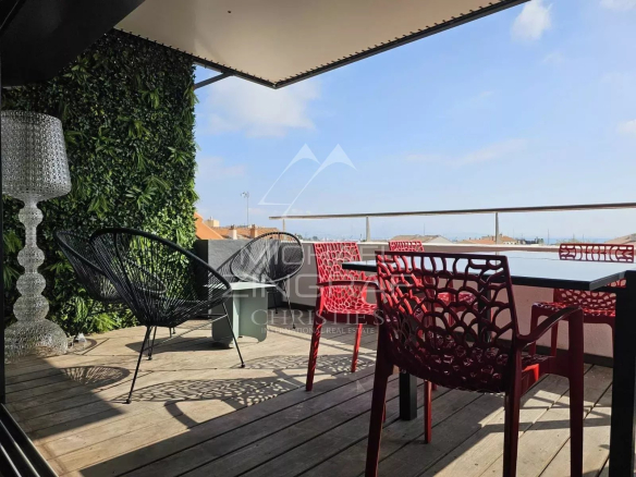 Terrasse d'un loft d'architecte à Antibes avec mobilier moderne et vue dégagée.