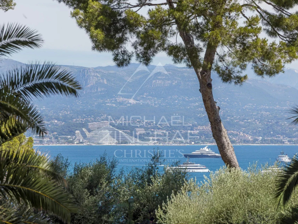 Vue sur la mer depuis une villa contemporaine au Cap d'Antibes, avec des yachts au loin.