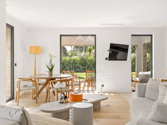 Intérieur d'une villa contemporaine avec salon et salle à manger, lumière naturelle abondante.