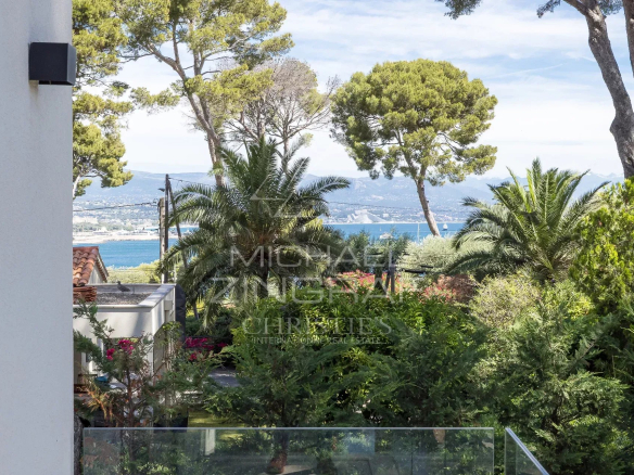 Vue sur la mer depuis une villa contemporaine avec des arbres et des plantes au Cap d'Antibes.