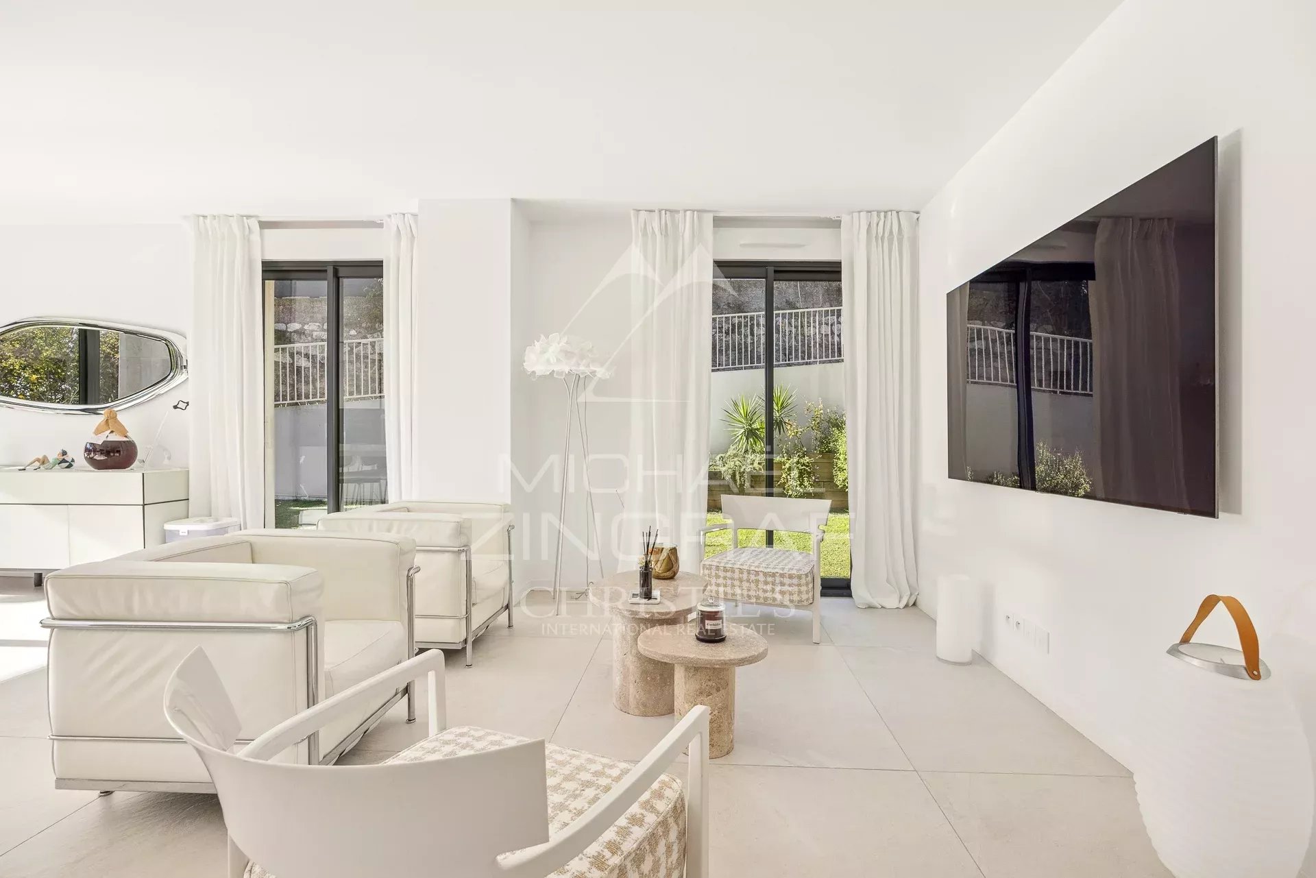 Intérieur d'un appartement moderne avec salon lumineux et accès à un jardin.