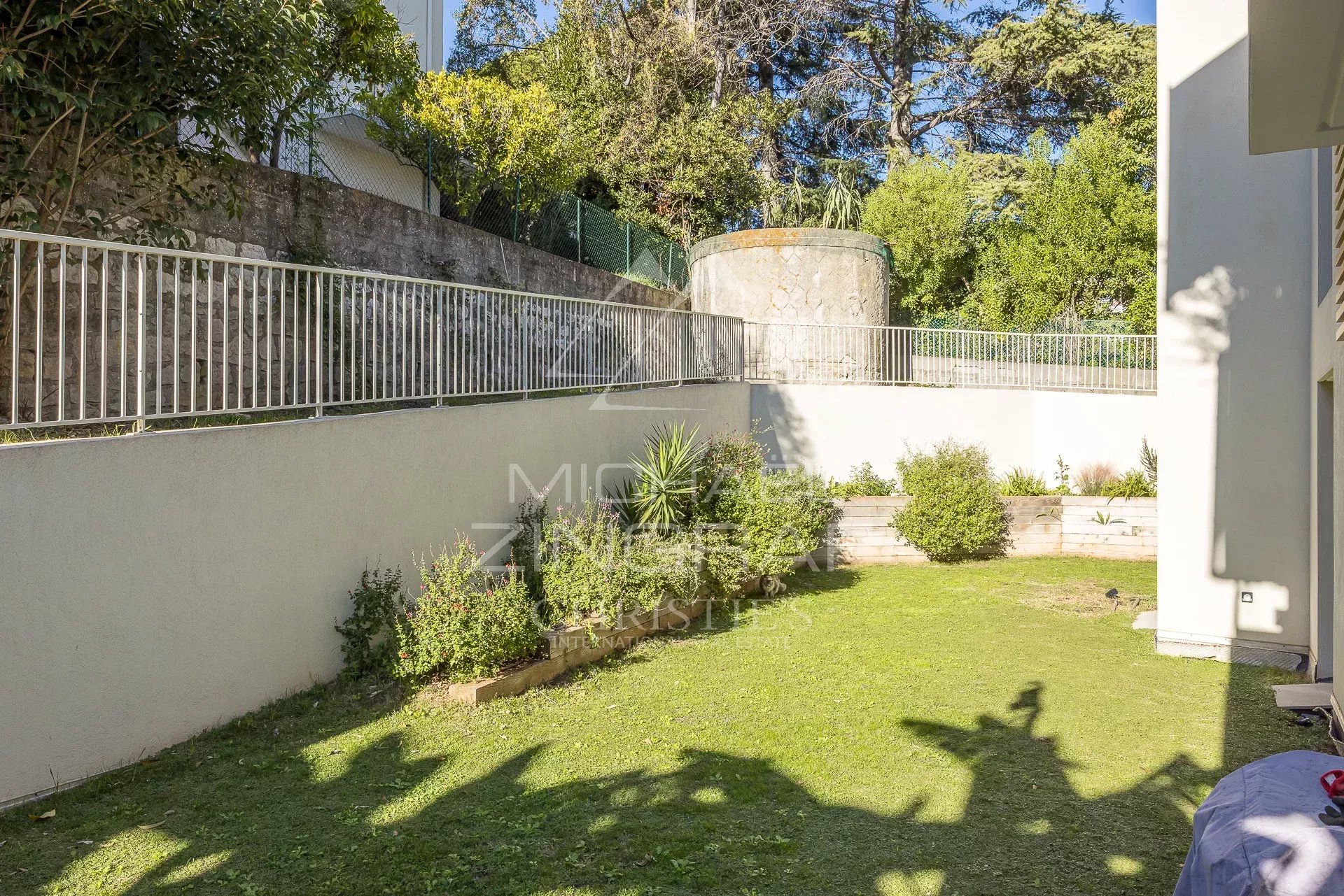 Jardin de 250 m² d'un appartement en rez-de-jardin à Antibes, avec pelouse et aménagement paysager.