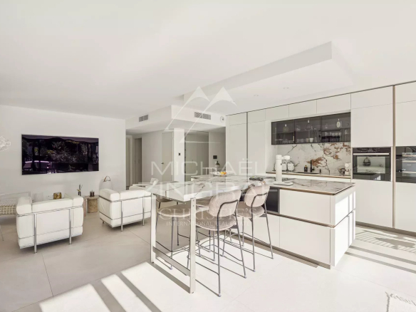Intérieur d'un appartement moderne avec salon lumineux et cuisine ouverte.