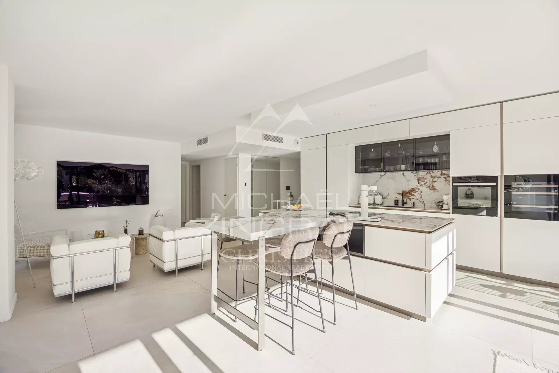 Intérieur d'un appartement moderne avec salon lumineux et cuisine ouverte.