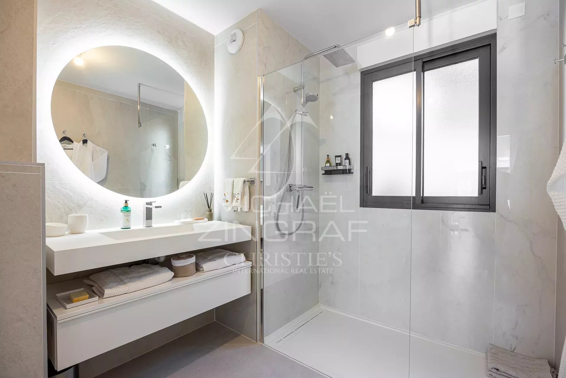 Salle de bain moderne avec douche à l'italienne et lavabo dans un appartement.