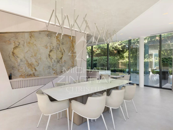 Intérieur d'une villa contemporaine avec salle à manger moderne et grandes baies vitrées.