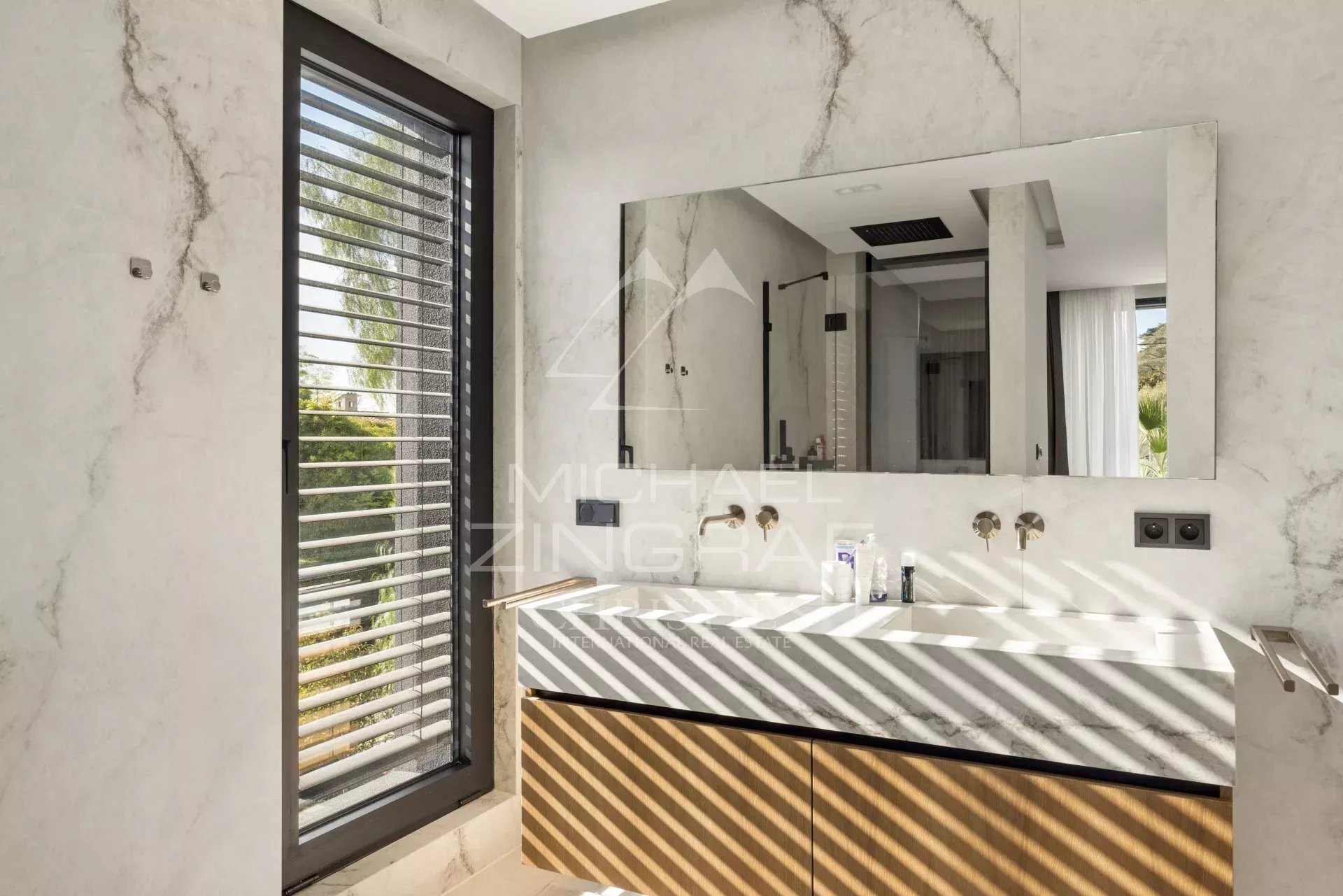 Salle de bain moderne avec lavabo en marbre et fenêtres à lattes.