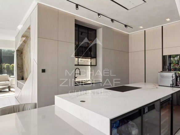 Intérieur moderne d'une cuisine contemporaine avec îlot central et équipements haut de gamme.