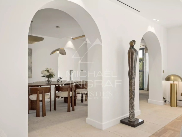 Intérieur d'une villa rénovée à Cap d'Antibes avec arches et mobilier moderne.