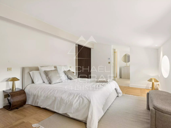 Chambre d'une villa rénovée au Cap d'Antibes avec lit double et décoration contemporaine.