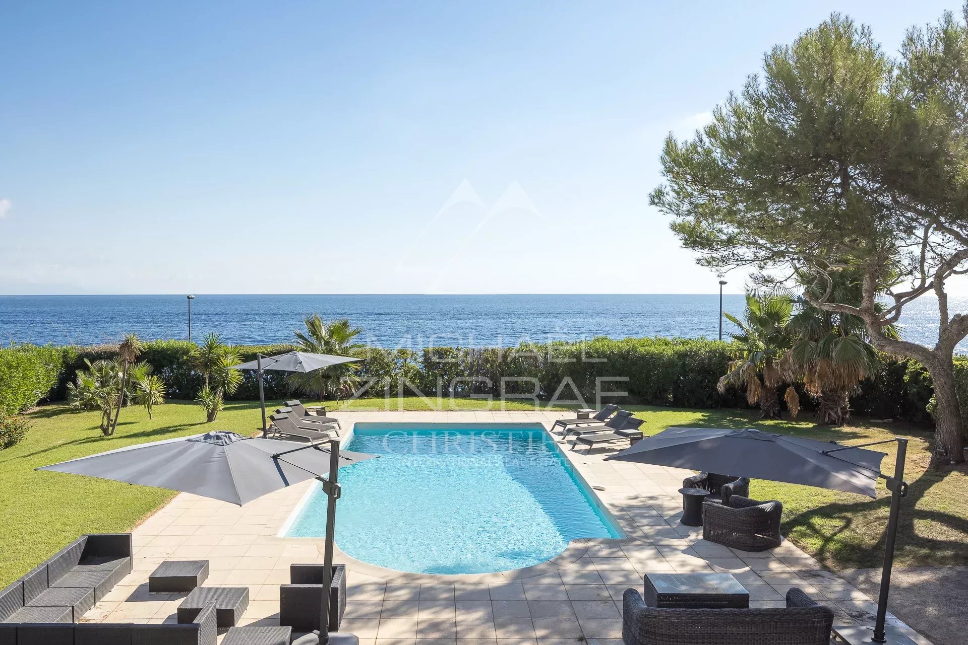 Exceptional villa in Cap d'Antibes View of the pool and garden of the villa in Cap d'Antibes with the sea in the background.