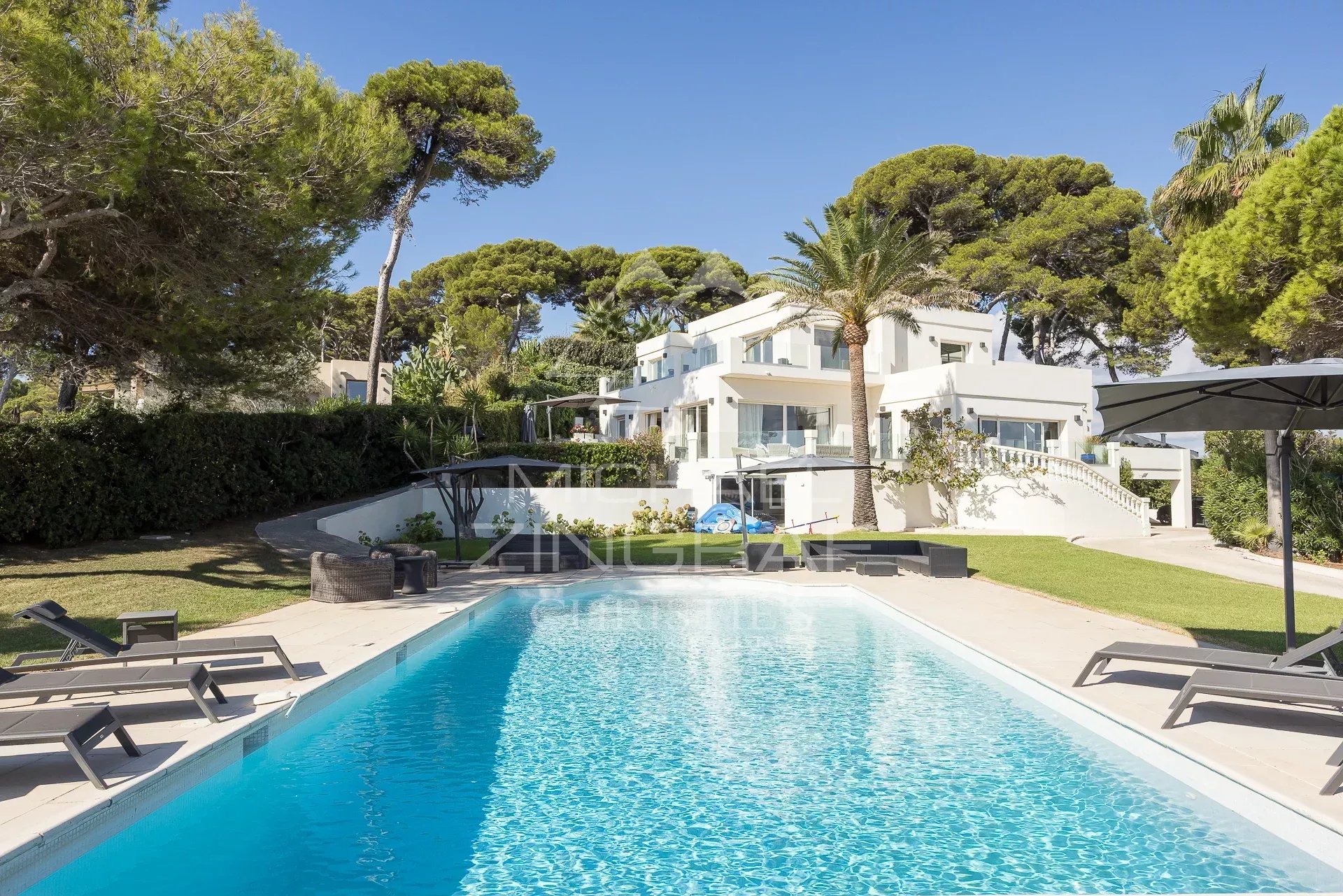 Exceptional villa in Cap d'Antibes Modern villa with swimming pool in Cap d'Antibes, surrounded by trees and outdoor spaces.