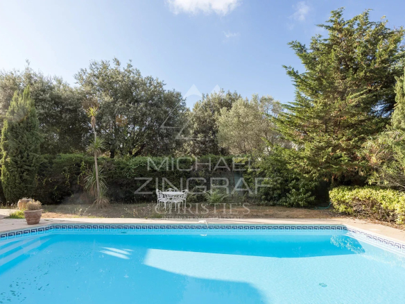 Swimming pool surrounded by greenery in a property in Antibes.