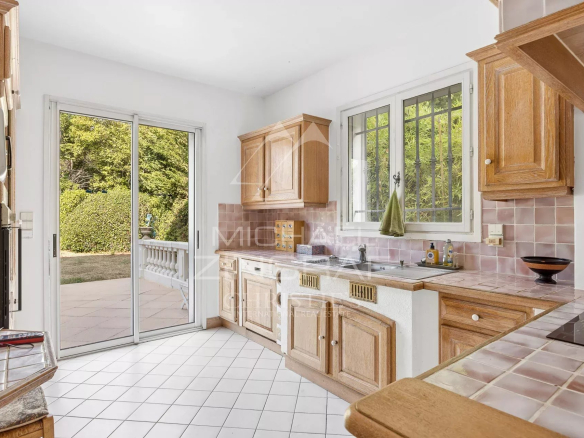 Bright kitchen with wooden furniture and access to the outside, located in Antibes.