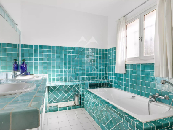 Bathroom with turquoise tiles, bathtub and sink.