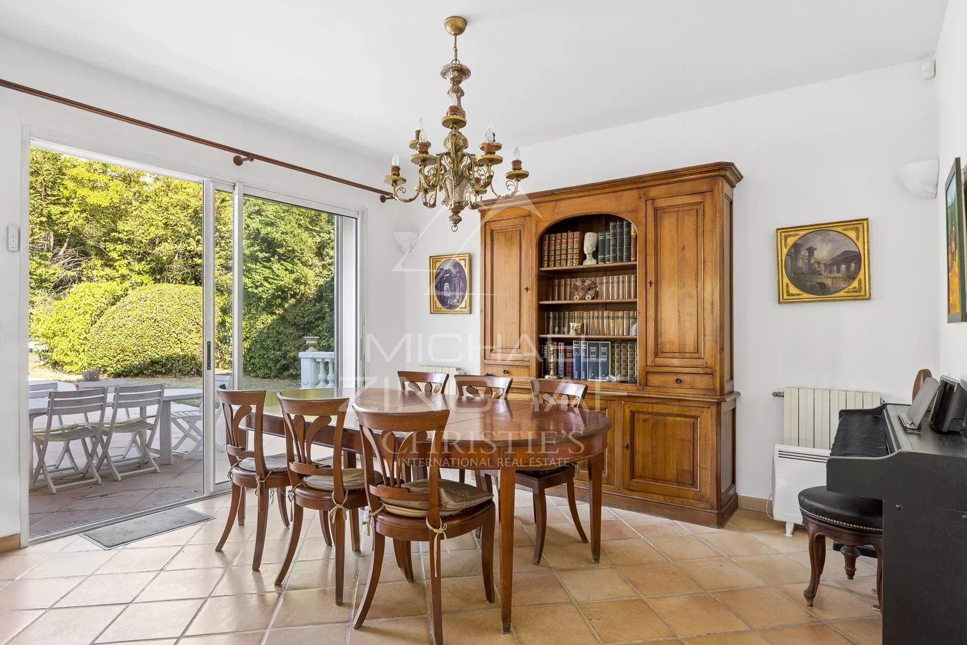 Spacious dining room Dining room with wooden table and bookcase, natural light through the windows.