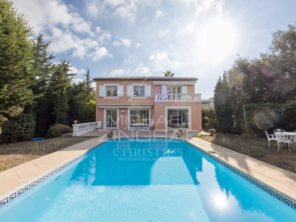 House with swimming pool and garden in Antibes, surrounded by trees and greenery.