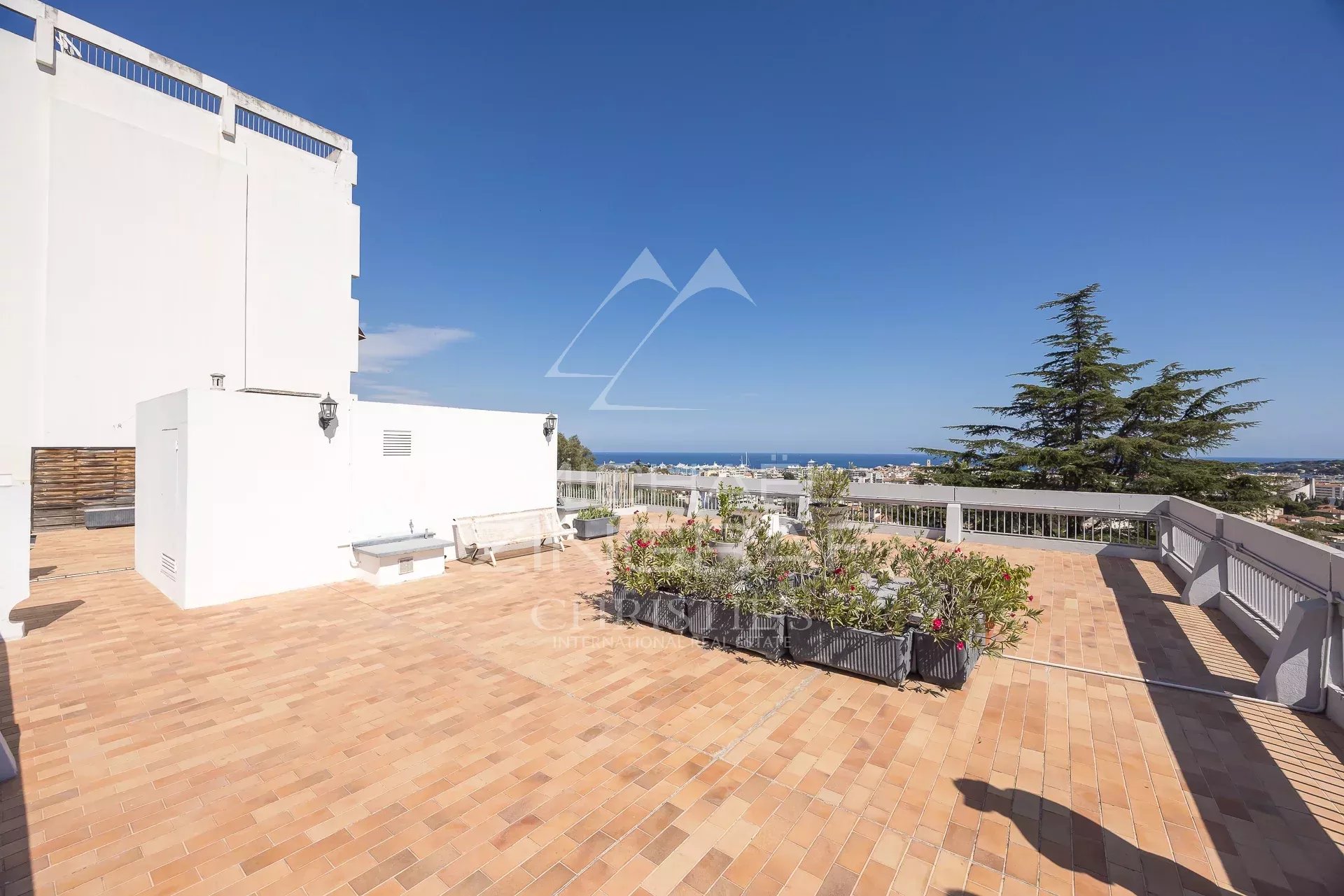 Terrasse avec vue panoramique à Antibes Terrasse spacieuse avec vue mer à Antibes, entourée de plantes et d'un espace aménagé.