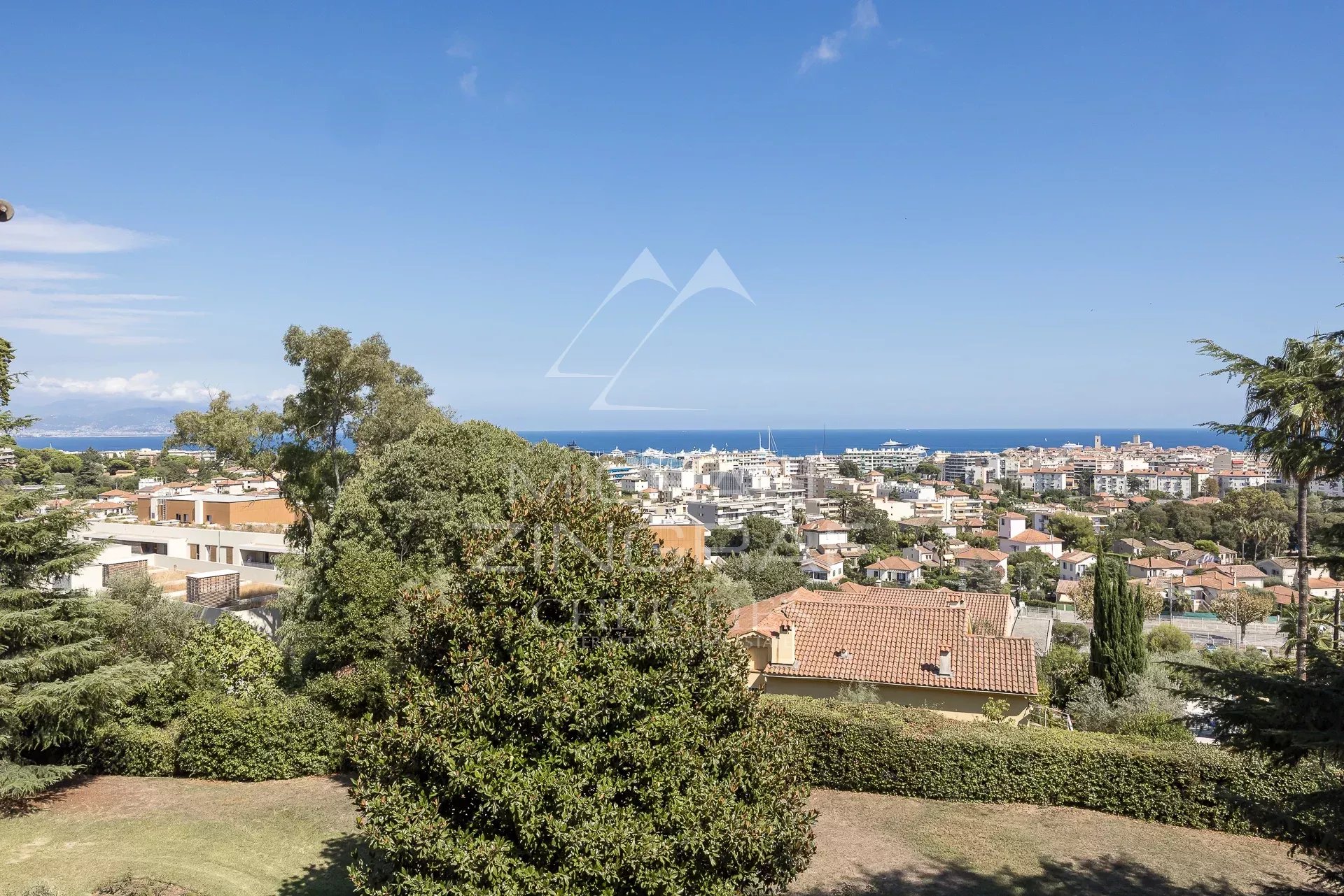 Vue sur Antibes et la mer Vue panoramique sur la mer et la ville d'Antibes depuis un espace vert.