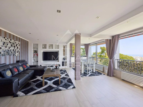 Salon spacieux d'un appartement à Antibes avec vue sur la mer et accès à une terrasse.
