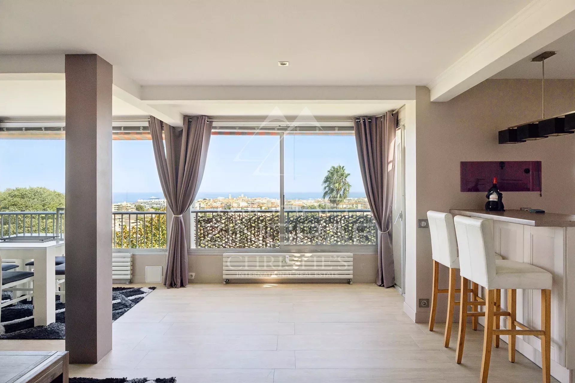 Appartement avec vue mer à Antibes Intérieur d'un appartement à Antibes avec vue mer, salon lumineux et espace bar.
