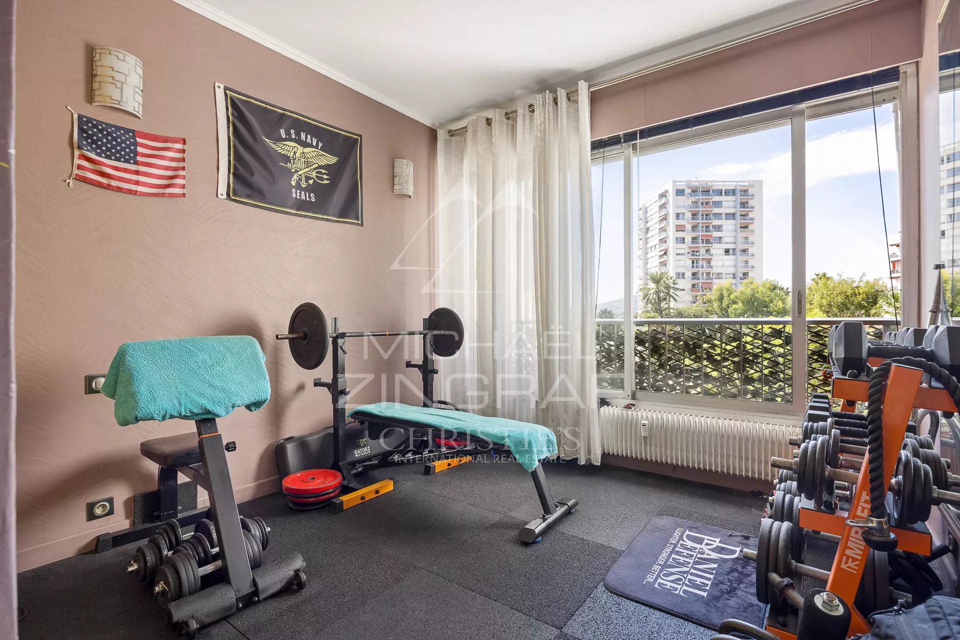 Salle de sport dans un appartement à Antibes Salle de sport avec équipements de fitness, fenêtres ouvertes sur un balcon à Antibes.