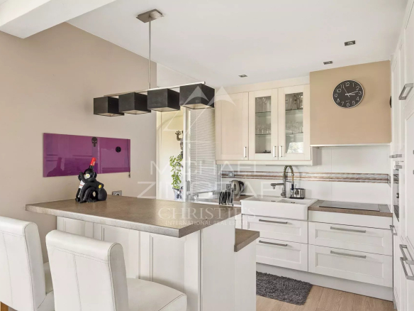Cuisine moderne et lumineuse d'un appartement à Antibes, avec bar et équipements contemporains.