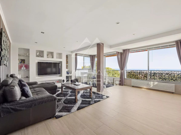 Salon spacieux d'un appartement à Antibes avec vue mer et accès à un balcon.