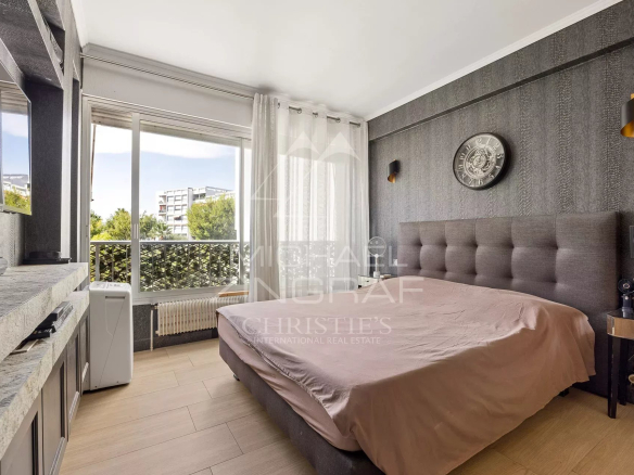 Chambre d'un appartement à Antibes avec lit double et balcon.