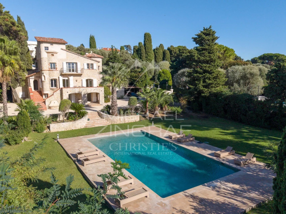 Propriété de luxe avec piscine sur le versant ouest du Cap d'Antibes, entourée de verdure.