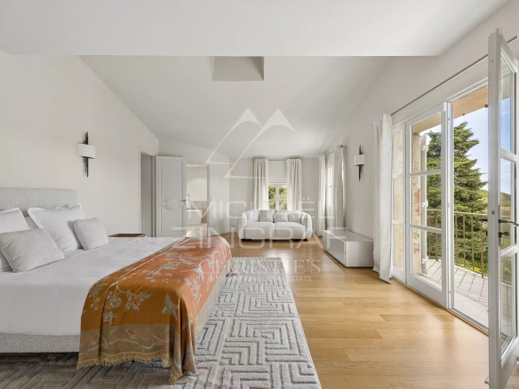 Chambre spacieuse avec lit double et vue sur la mer, décor moderne et lumineux.