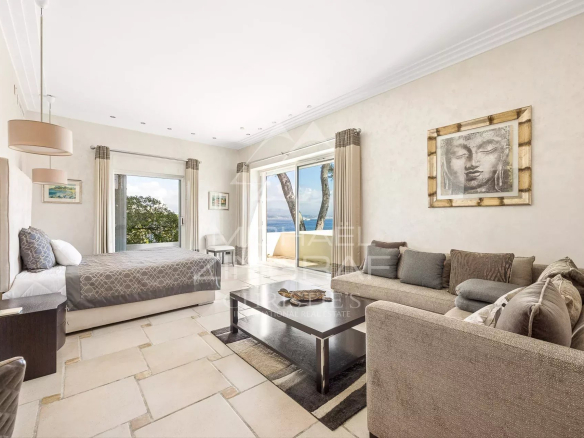 Intérieur d'une villa à Cap d'Antibes avec vue sur la mer, salon et chambre élégants.