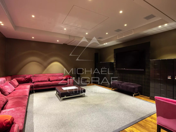 Intérieur d'une villa avec un salon confortable, canapé en velours rouge et éclairage doux.