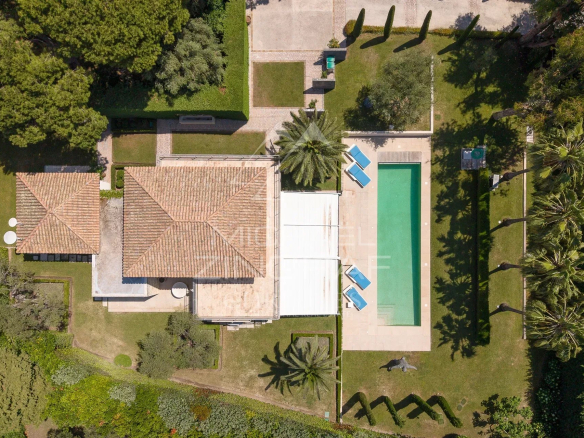 Vue aérienne d'une villa néo-provençale avec piscine et jardin à Cap d'Antibes.