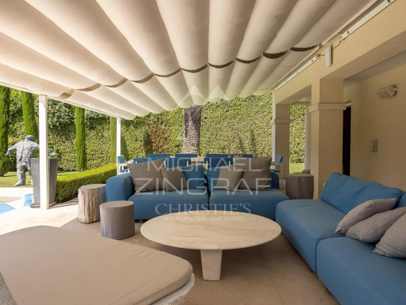 Terrasse d'une villa néo-provençale avec mobilier moderne et jardin verdoyant à Antibes.