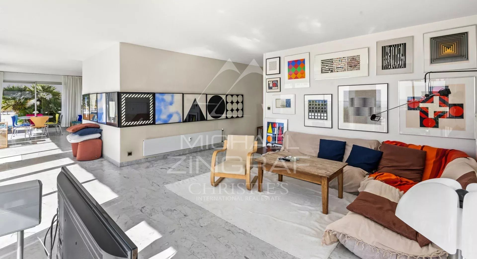 Villa sur le toit à Juan-les-Pins Intérieur d'une villa sur le toit avec salon lumineux et œuvres d'art, vue sur la mer.