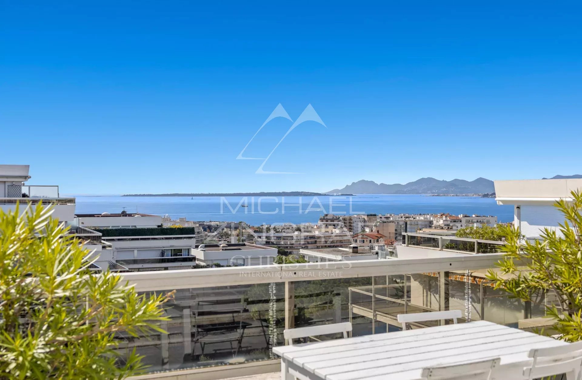 Villa sur le toit avec vue mer à Antibes Vue panoramique depuis une villa sur le toit à Antibes, avec mer et montagnes en arrière-plan.
