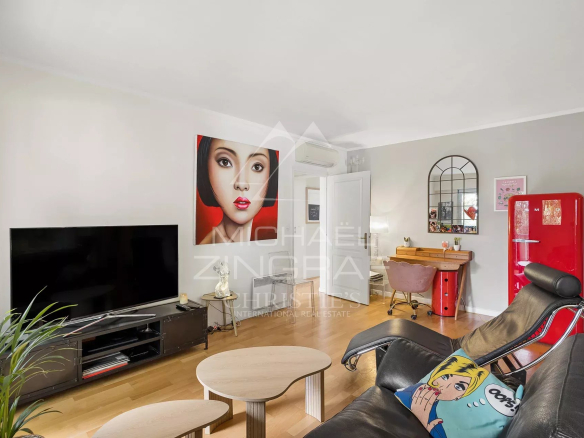 Salon d'un appartement à Cap d'Antibes avec télévision, fauteuils et décoration moderne.