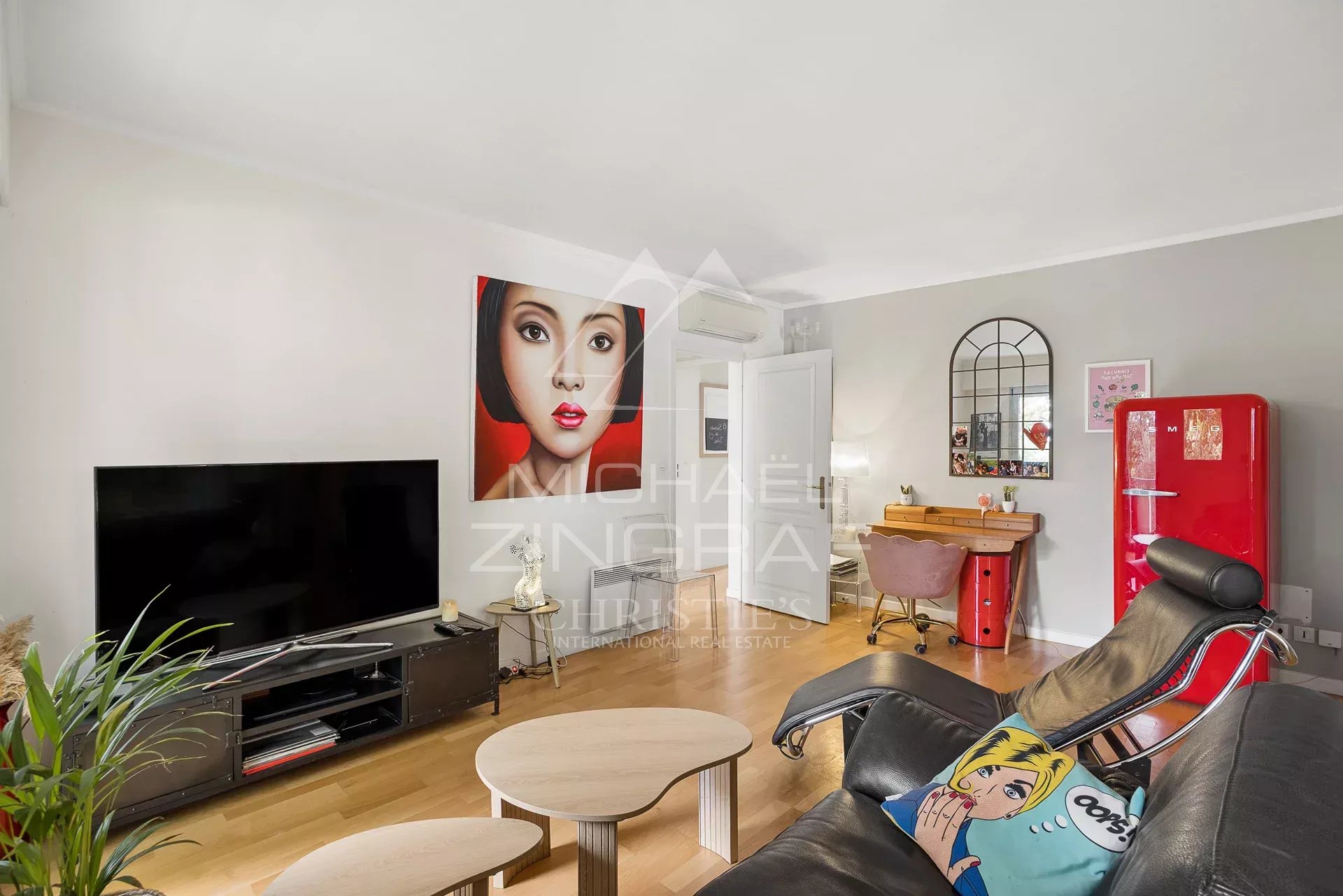 Salon d'un appartement à Cap d'Antibes avec télévision, fauteuils et décoration moderne.