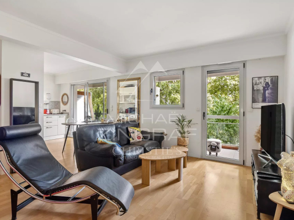 Intérieur d'un appartement moderne avec un salon lumineux et un fauteuil design, situé à Cap d'Antibes.