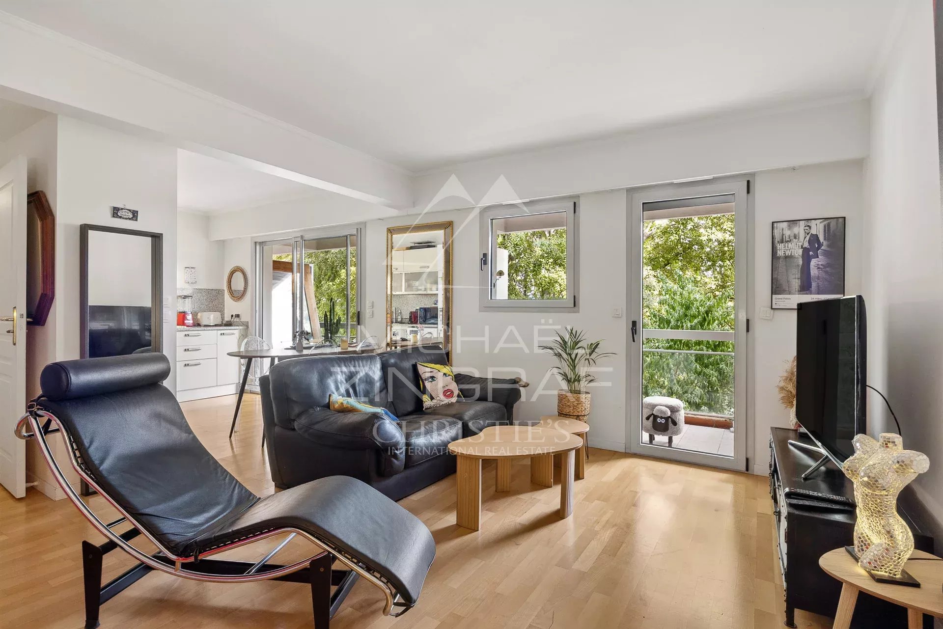 Intérieur d'un appartement moderne avec un salon lumineux et un fauteuil design, situé à Cap d'Antibes.