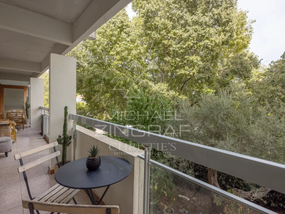 Balcon d'un appartement au Cap d'Antibes avec vue sur un parc arboré.