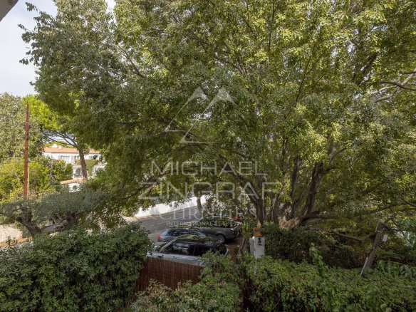 Vue depuis un appartement à Cap d'Antibes, avec des arbres et des voitures visibles.